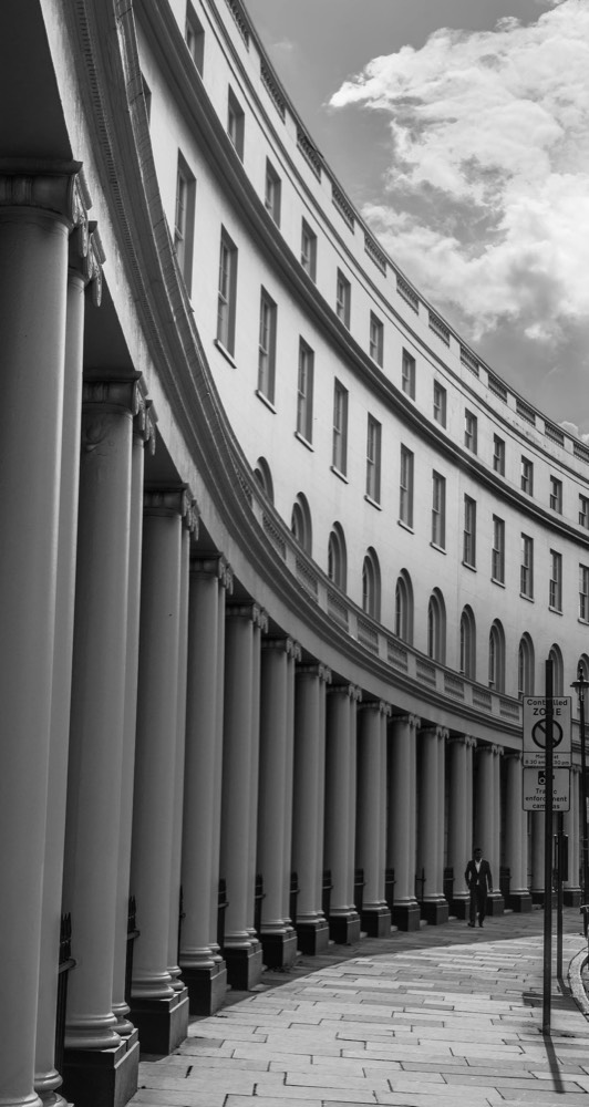 A curving stucco colonnade on a London terrace, black and white