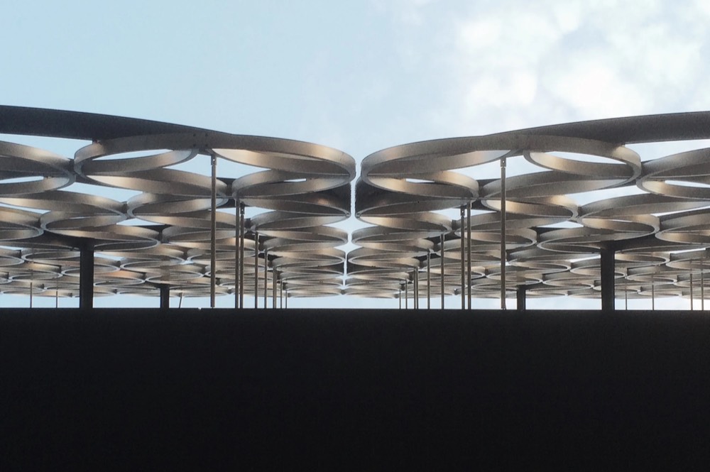 A sweeping modern canopy roof against a pale sky
