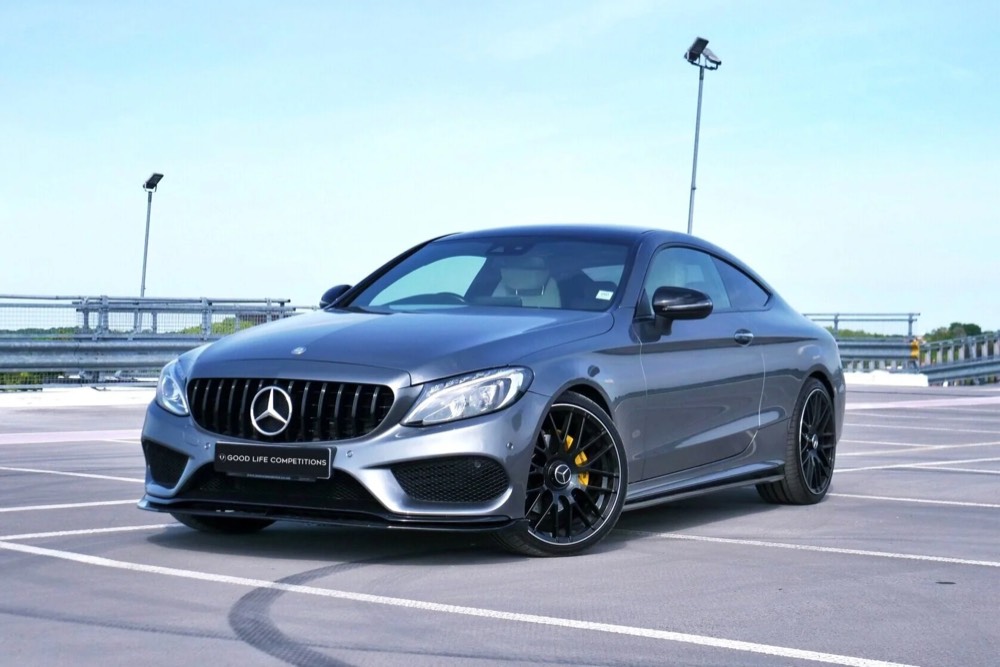A grey Mercedes-AMG coupé on a rooftop car park