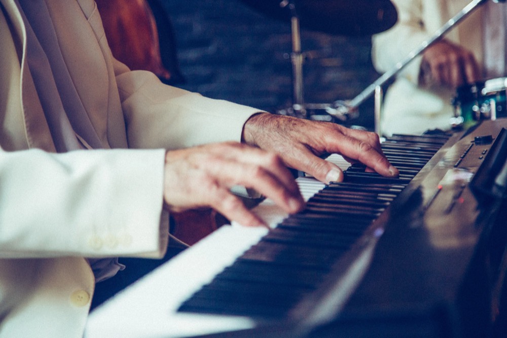 A pianist in a white jacket at the keys